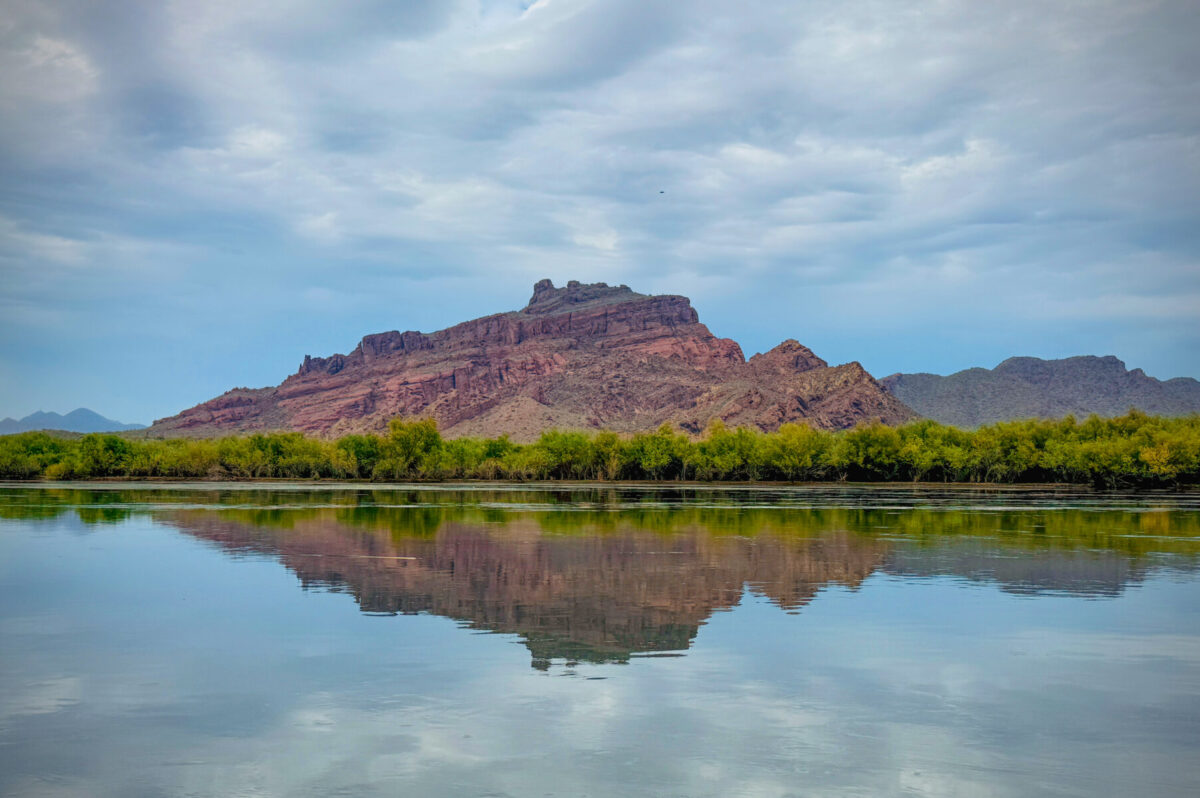 A peaceful river scene with a rock formation in the background