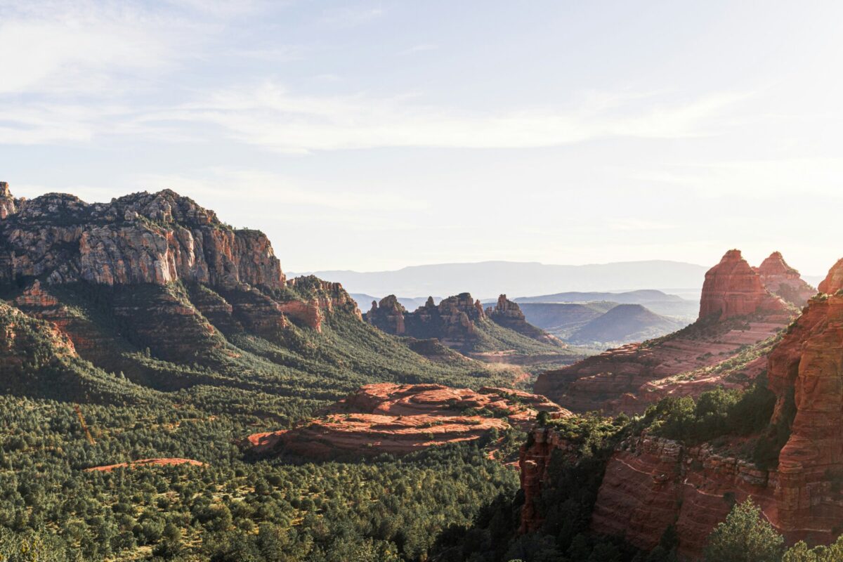 Red rock formations and lush green valley in Sedona, Arizona on a clear day.