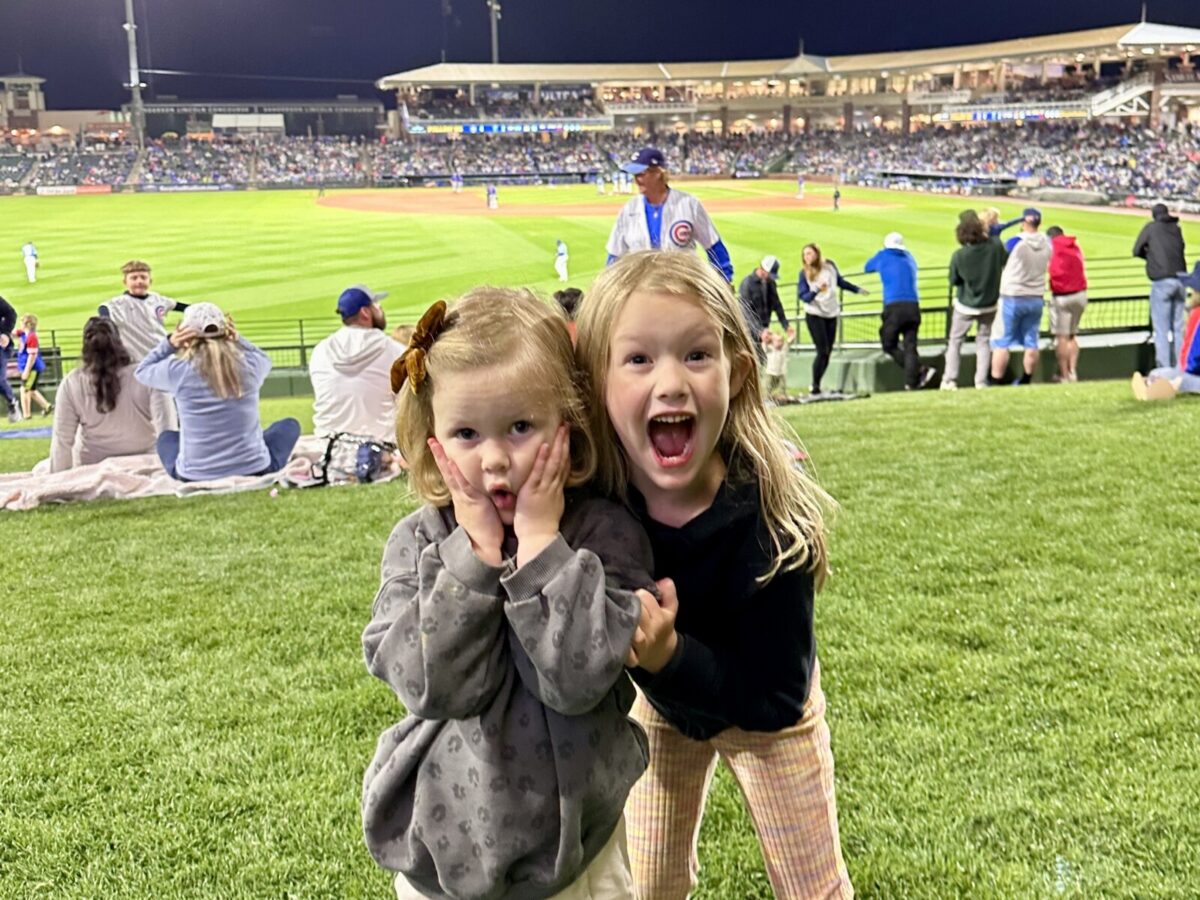 Children enjoying a nighttime baseball game at Surprise Stadium.